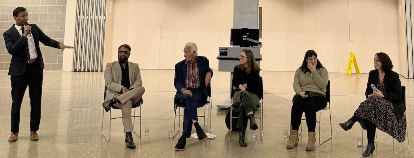 Panel discussion at Kingston University London on “The Business of Food & Drinks,” featuring industry founders and speakers seated on stage beneath a large presentation screen.